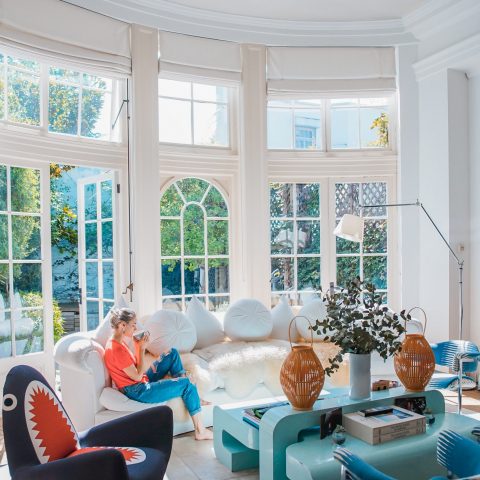 woman sitting on white couch near window